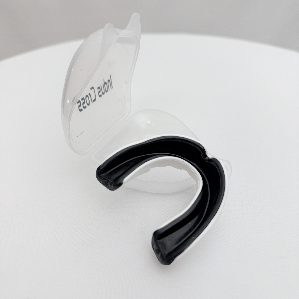 Black mouthguard with clear cover on a white surface
