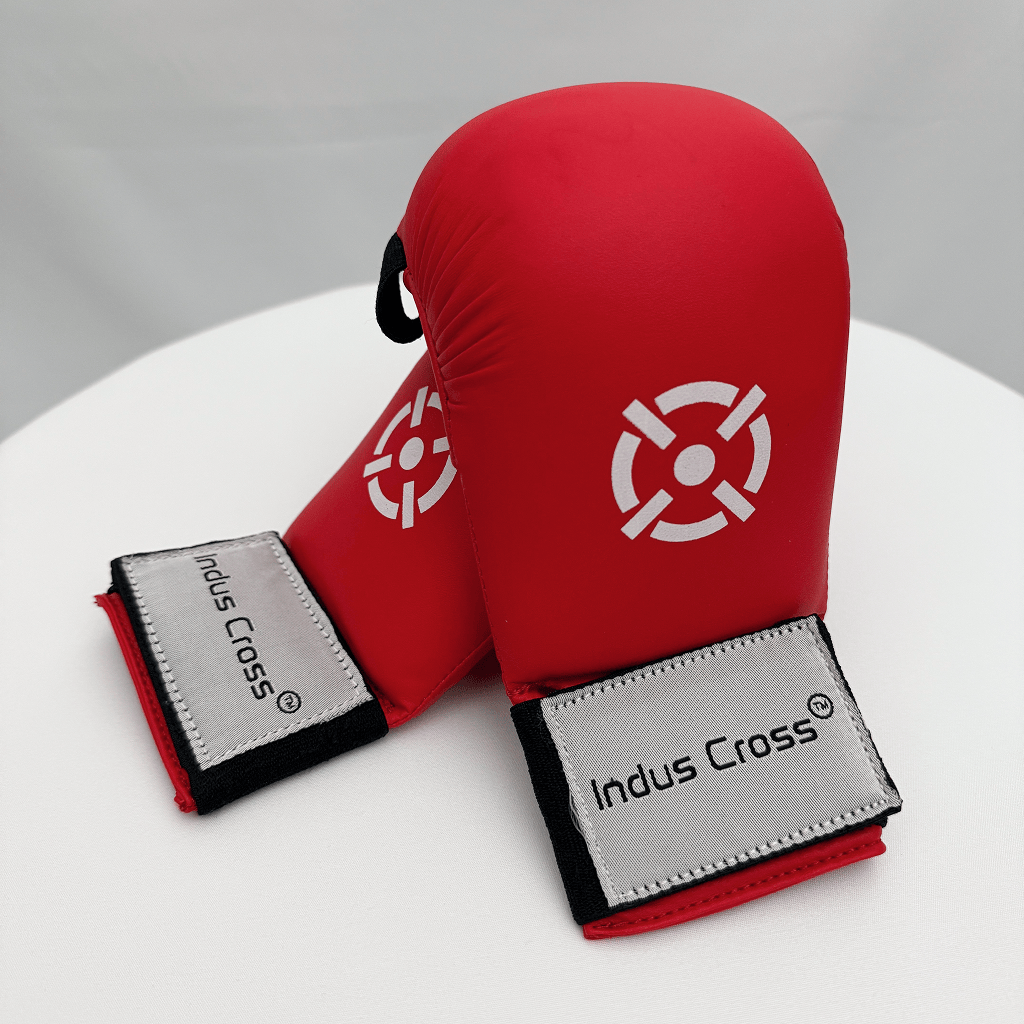 Red karate gloves with 'Indus Cross' branding on a white surface.