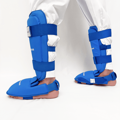 Blue shin guards on a person's legs against a white background