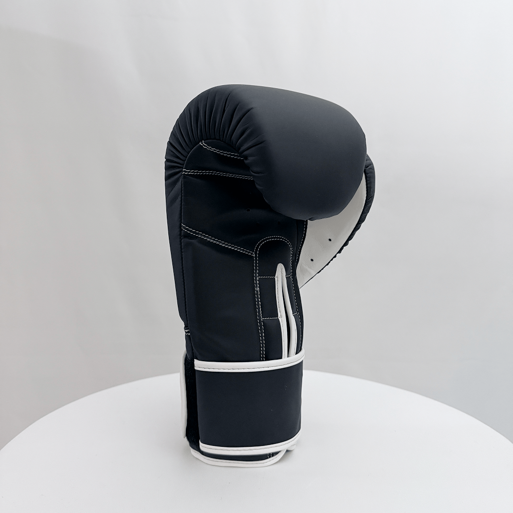Black boxing glove on a white stand against a light gray background