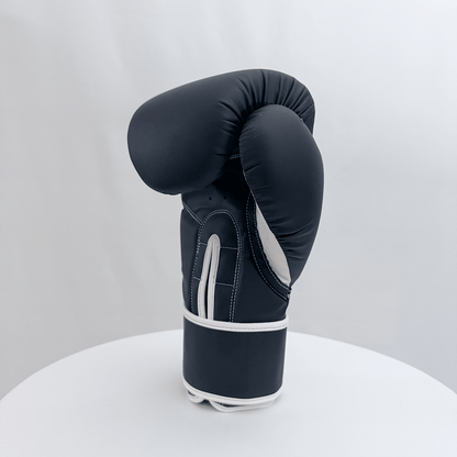 Black boxing glove on a white stand with a white background