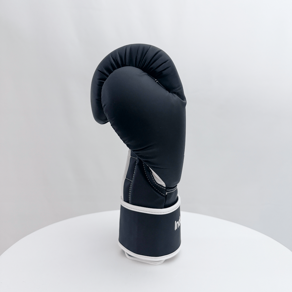 Black boxing glove on a white stand against a light gray background