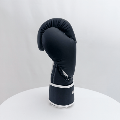 Black boxing glove on a white stand against a light gray background