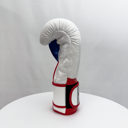 White boxing glove with red and blue accents on a white surface and gray background