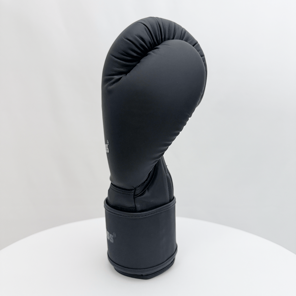 Black boxing glove on a white stand against a white background