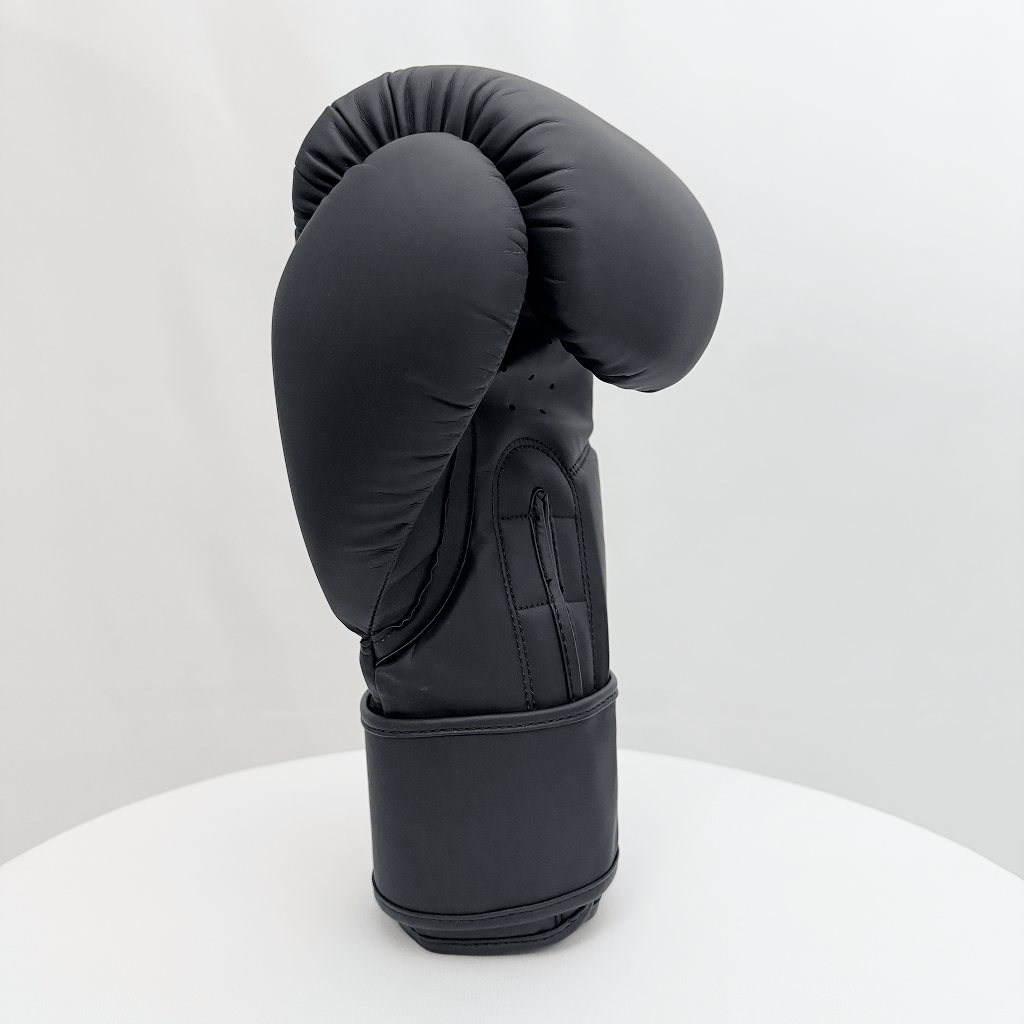 Black boxing glove on a white stand against a white background