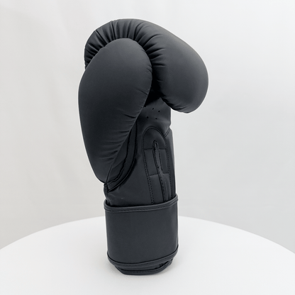 Black boxing glove on a white stand against a white background