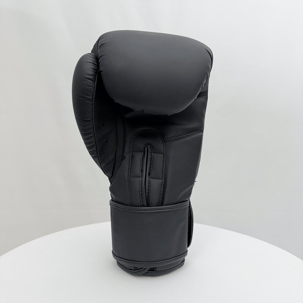 Black boxing glove on a white stand with a white background