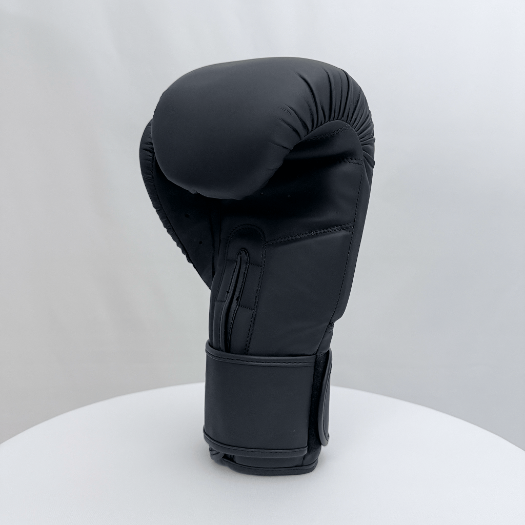 Black boxing glove on a white stand against a light gray background