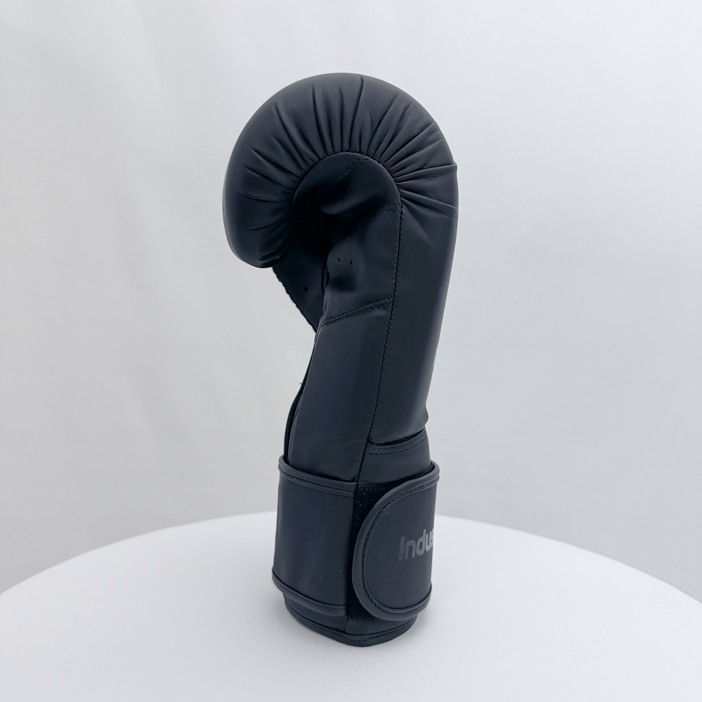 Black boxing glove on a white stand with a white background