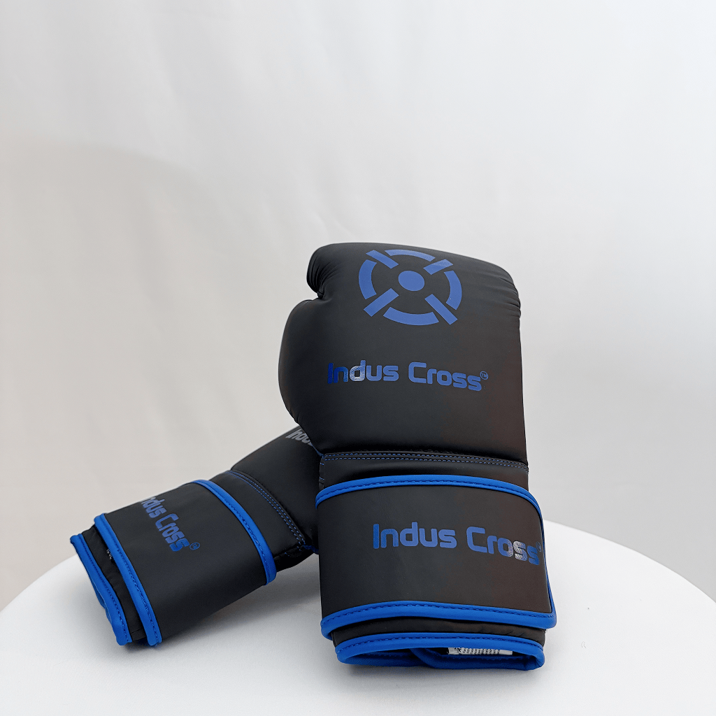 Black and blue boxing gloves with 'Indus Cross' branding on a white surface.