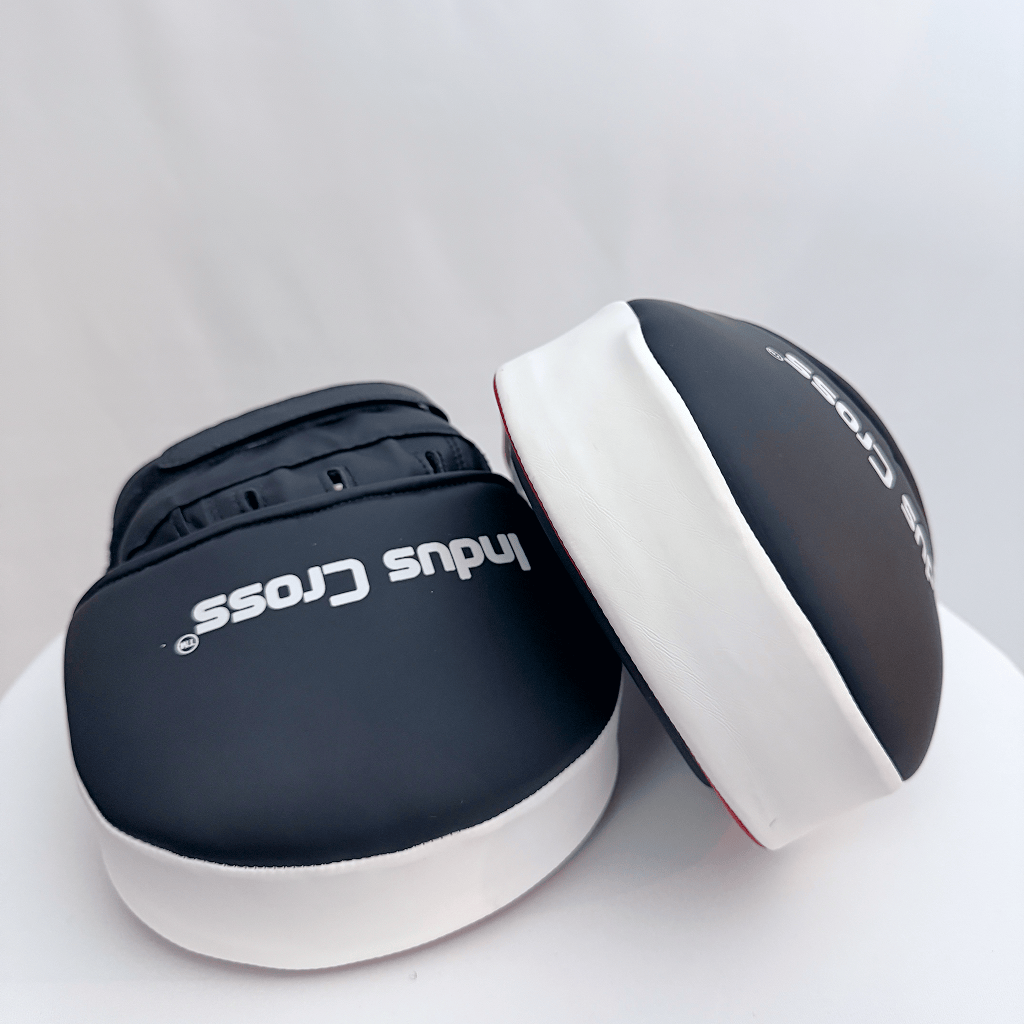 Pair of red and black boxing focus mitts on a white background