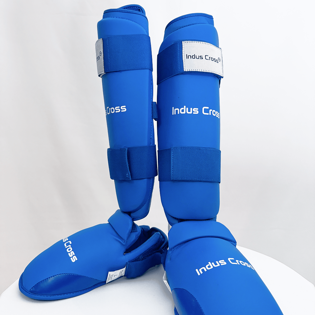 Pair of blue shin guards with 'Indus Cross' branding on a white background
