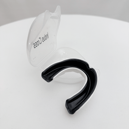 Black mouthguard with clear cover on a white surface