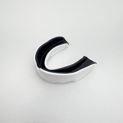 Black and silver mouthguard on a light gray background