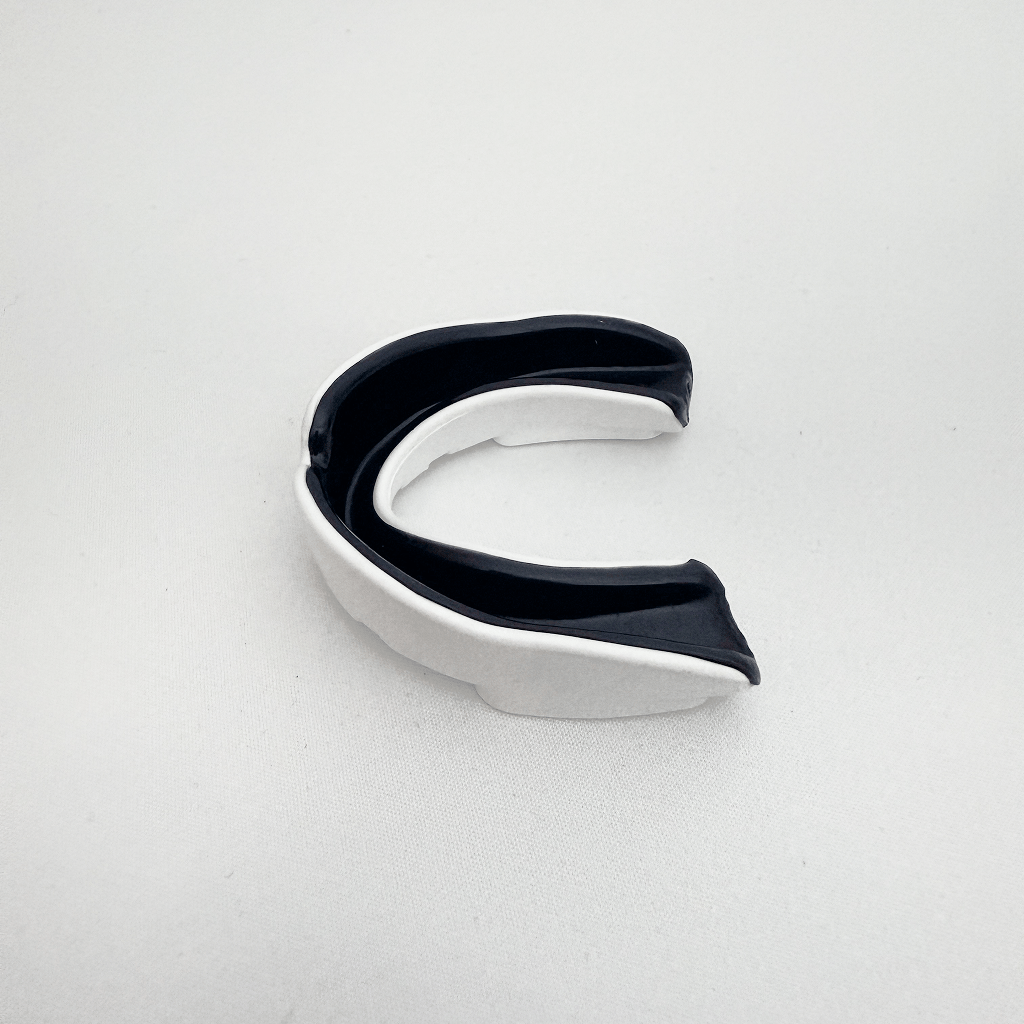 Black and white mouthguard on a light gray background