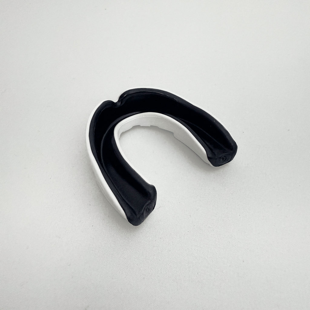 Black and white mouthguard on a light gray background