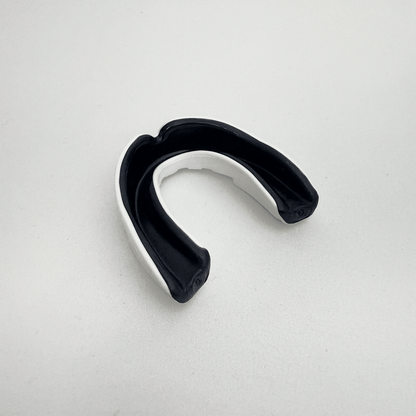 Black and white mouthguard on a light gray background