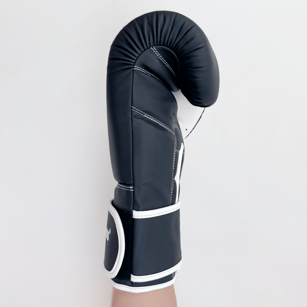 Black boxing glove with white accents on a light gray background