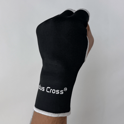 A person's hand wearing black inner gloves with 'Indus Cross' branding