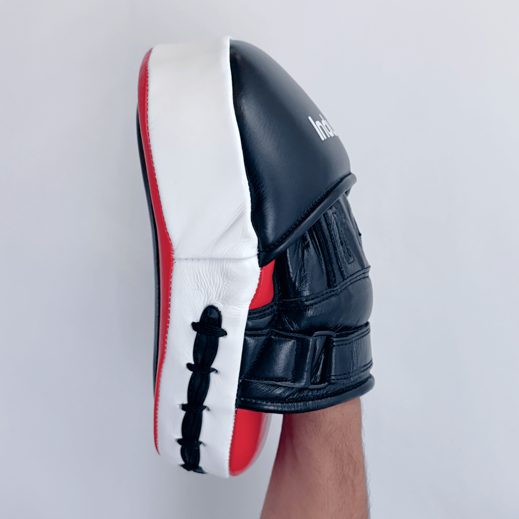 Red and black boxing focus mitt on a hand on a white background