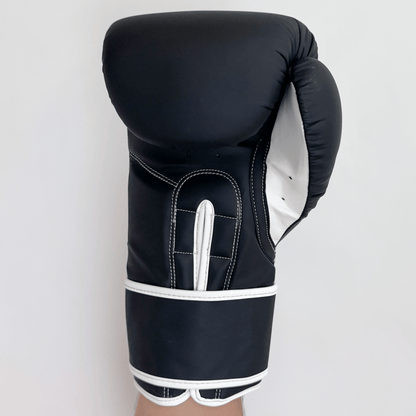 Black boxing glove with white accents on a light gray background