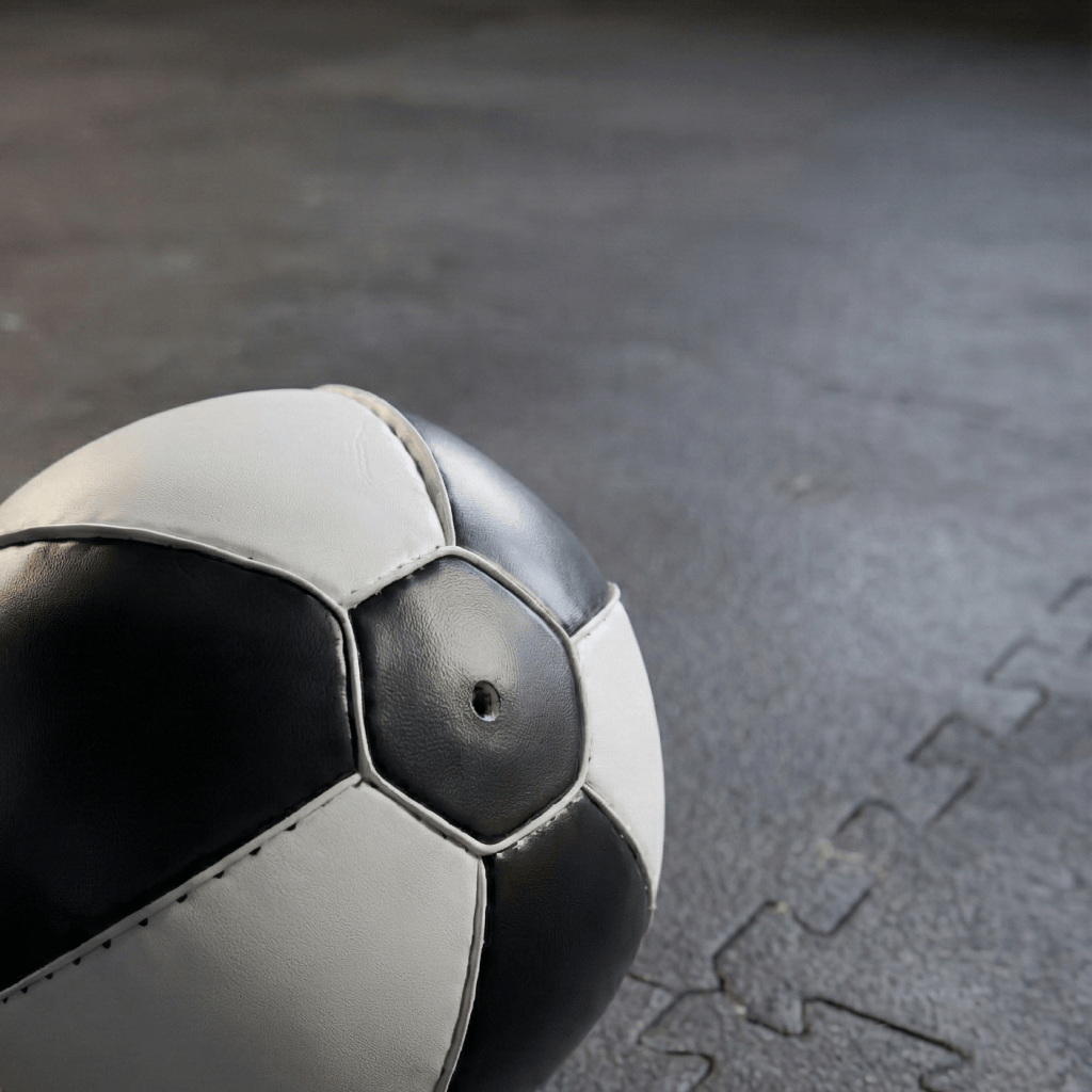 Close-up of a black and white Indus Cross Elite Boxing Speed Bag -Genuine Leather on a textured surface.