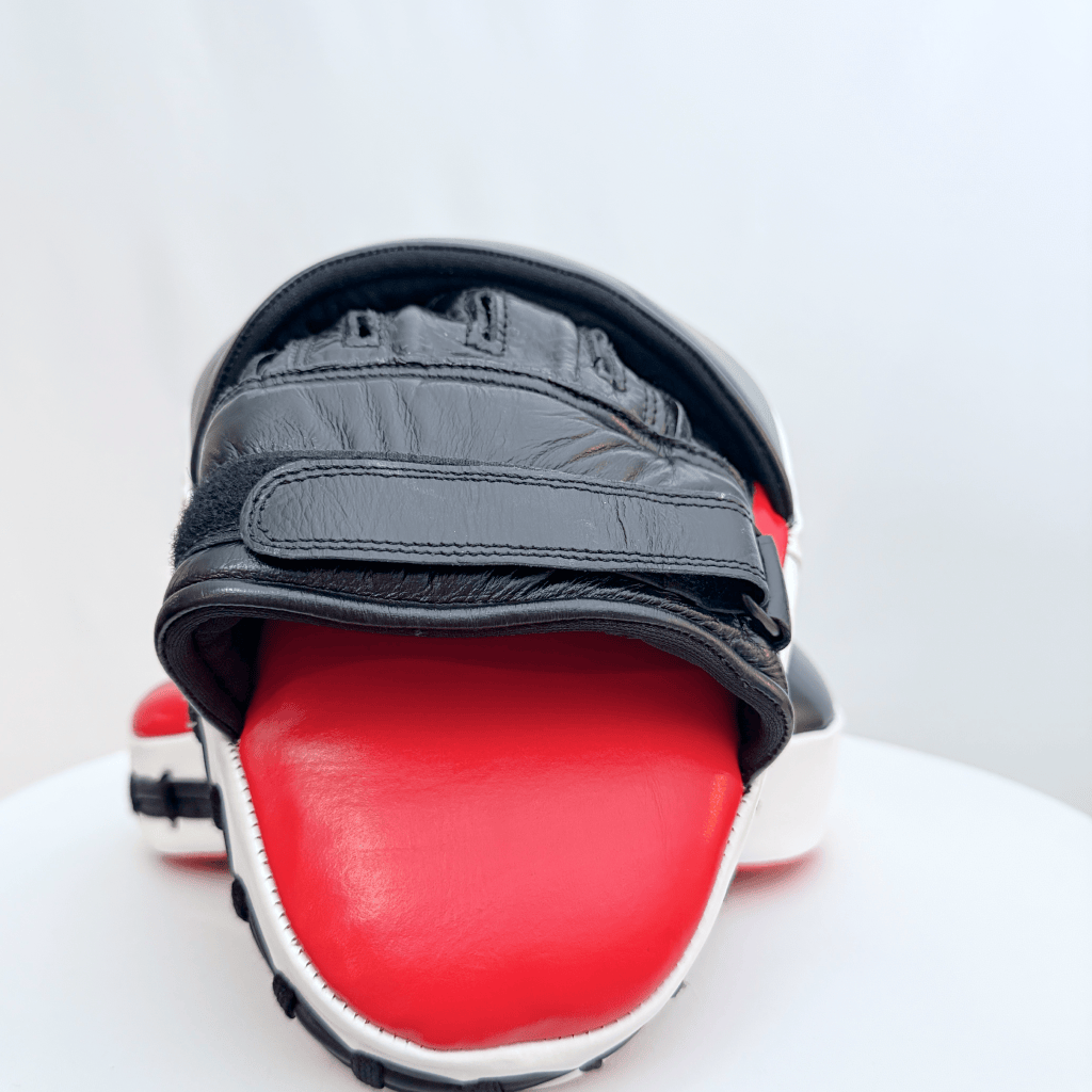 Pair of red and black boxing focus mitts on a white background