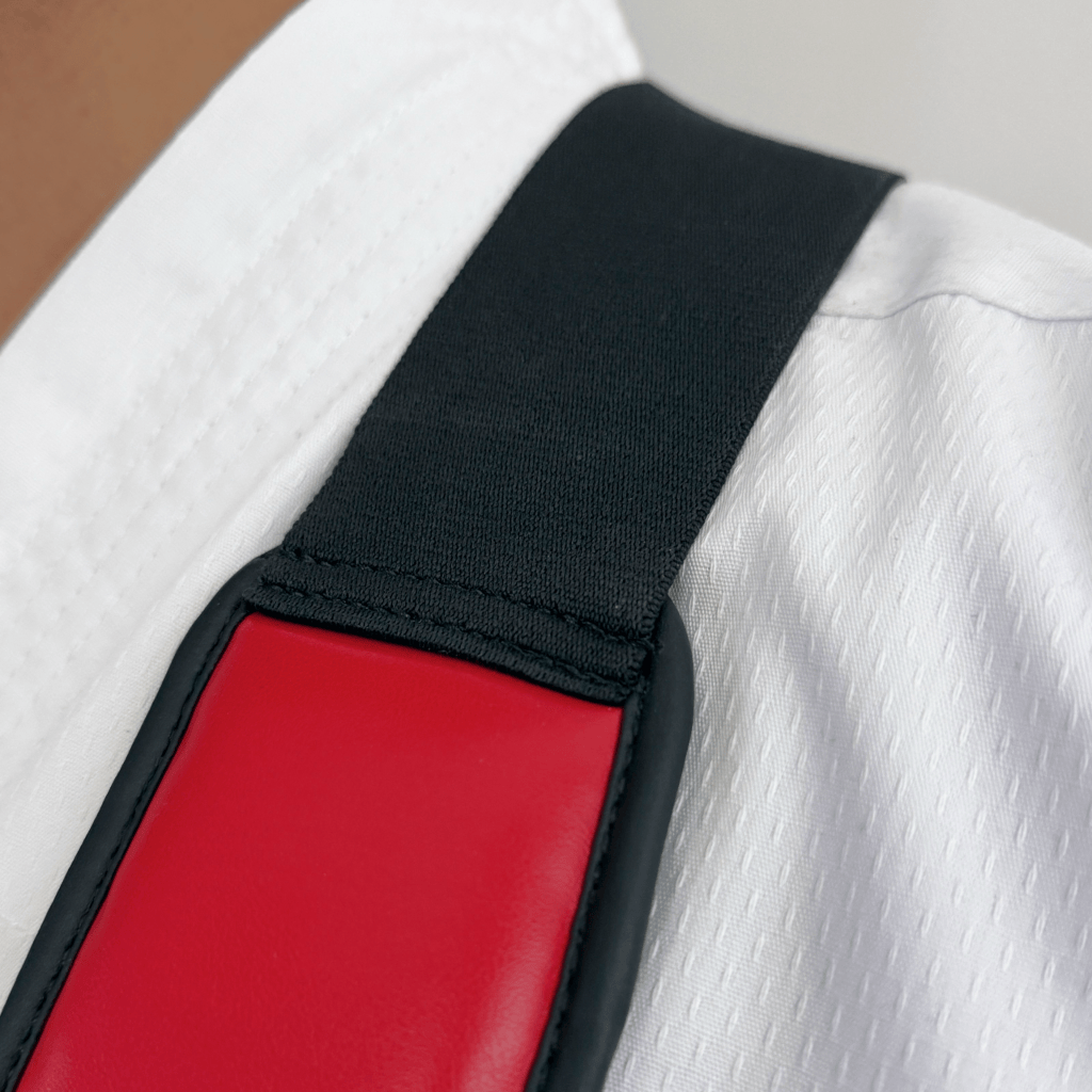 Close-up of a red chest guard on a white martial arts uniform.