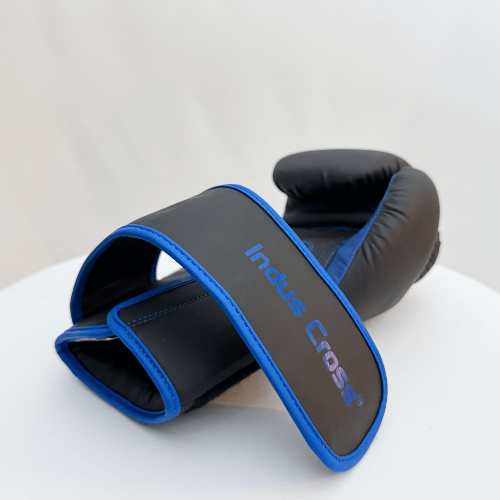 Black and blue boxing glove on a white surface with 'Indus Cross' branding.