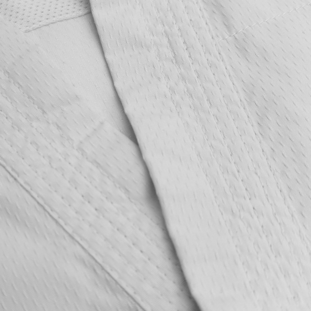 Close-up of a White Indus Cross Lightweight Karate Suit (White Belt Included). 