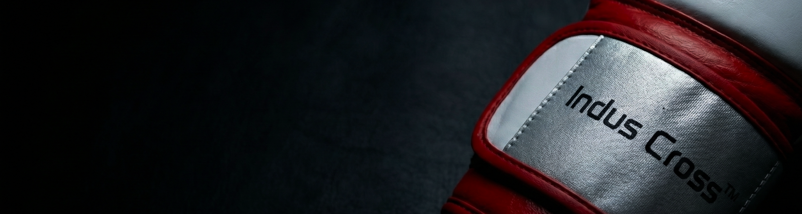 Red and gray boxing glove with 'Indus Cross' branding on a dark background