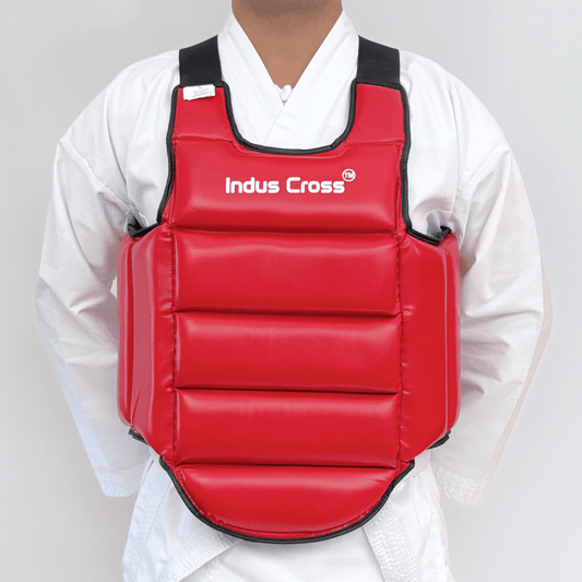 Red chest guard with 'Indus Cross' branding worn by a person in a white martial arts uniform.
