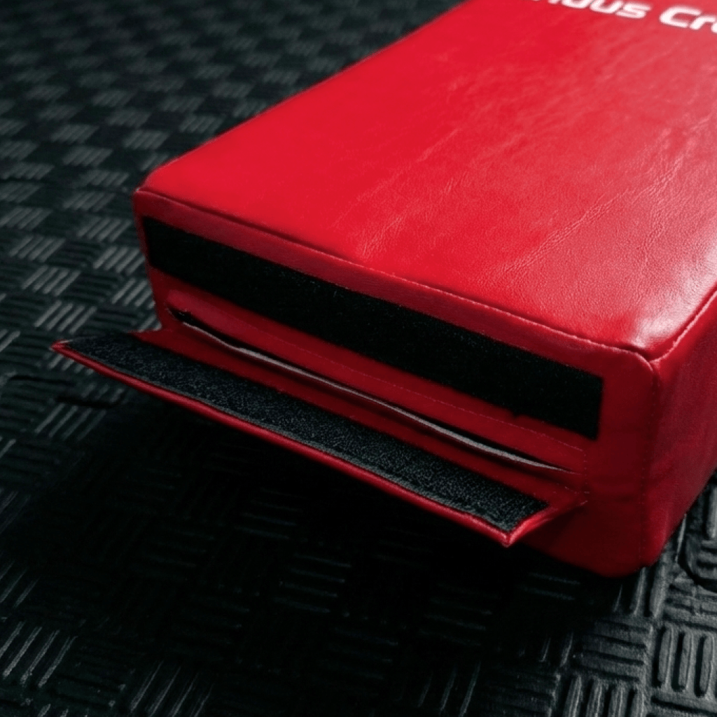 Red kick shield's strap on a textured black surface