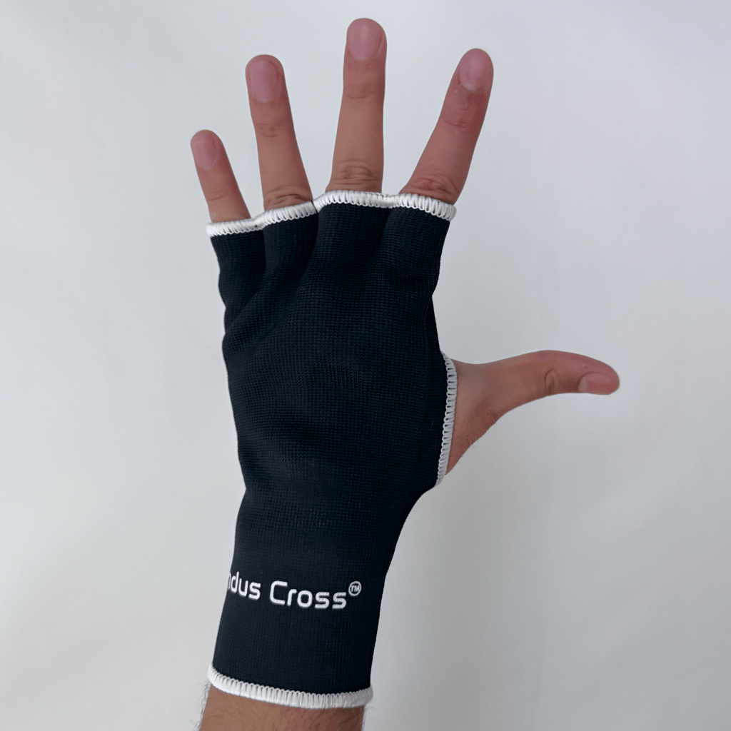 A person's hand wearing black inner glove with 'Indus Cross' branding