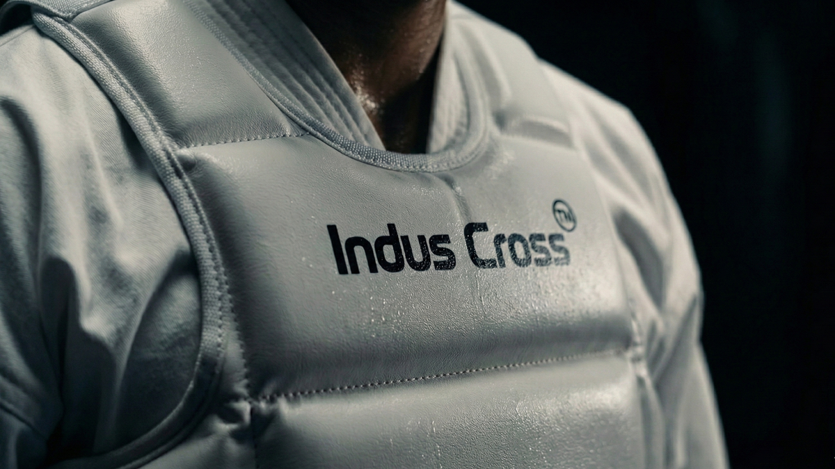 White karate chest gear with 'Indus Cross' branding on a dark background